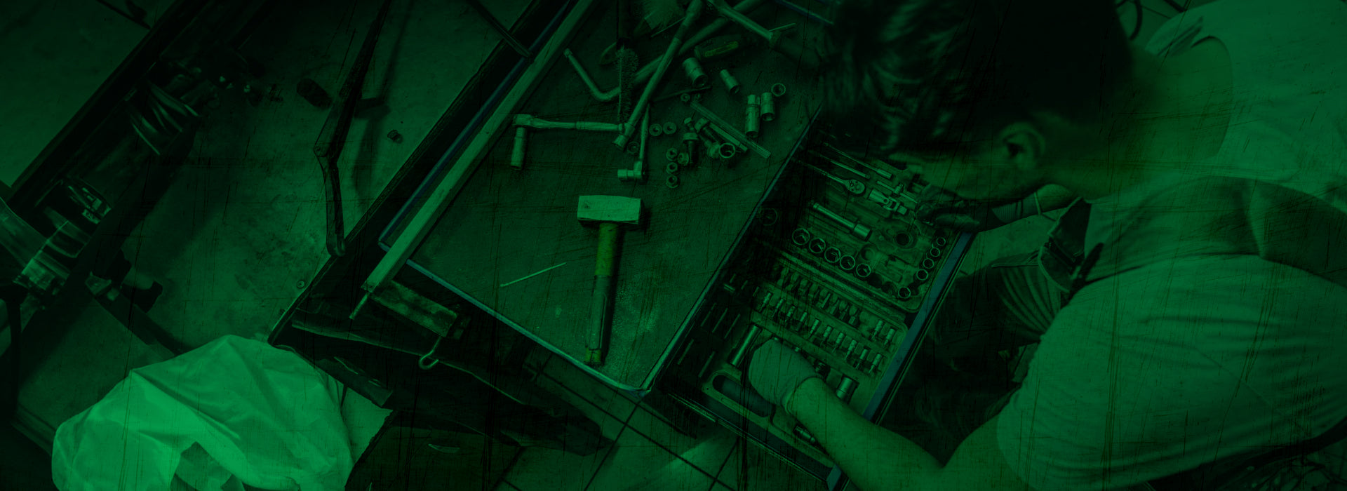Two people working on a large electronic control panel in a dimly lit room.